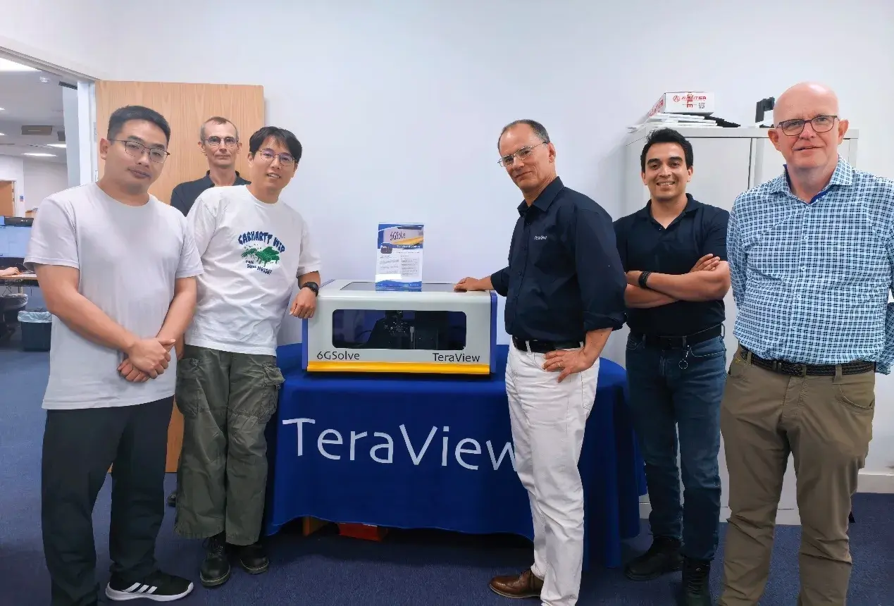 Strategic Partnership|IEST Instrument and TeraView Join Forces to Advance Battery Electrode Inspection 2 IEST Instrument team and TeraView engineering teams during a technical exchange visit at TeraView's UK facility, with a TeraView terahertz instrument on display.